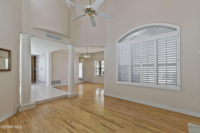 unfurnished living room featuring ornate columns, visible vents, a ceiling fan, and hardwood / wood-style flooring