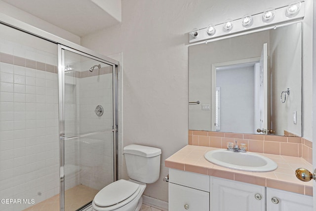 full bath featuring vanity, baseboards, toilet, and a shower stall