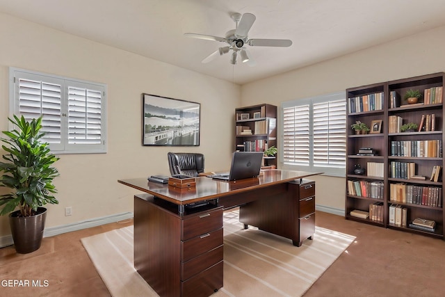 home office featuring light colored carpet, ceiling fan, and baseboards