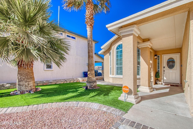 property entrance featuring a lawn