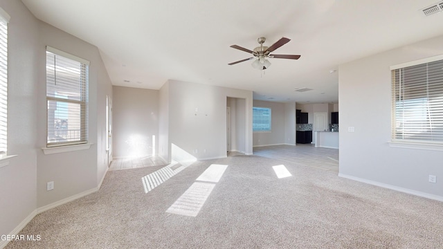 carpeted empty room featuring ceiling fan