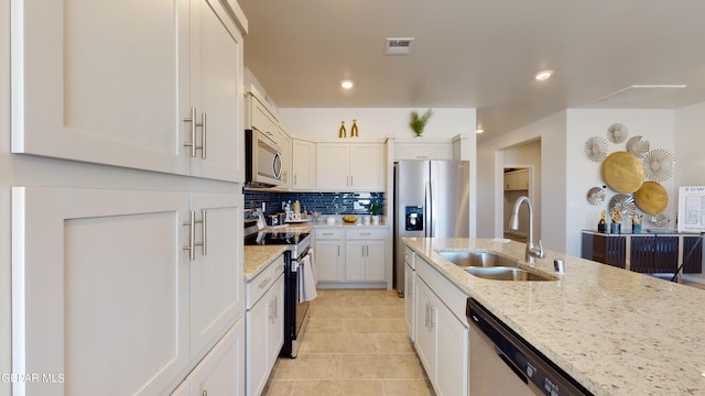 kitchen featuring light stone countertops, appliances with stainless steel finishes, sink, and white cabinets