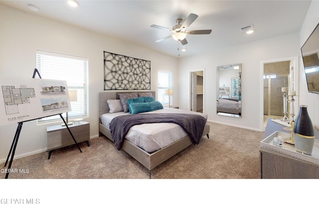 carpeted bedroom with a spacious closet, connected bathroom, and ceiling fan