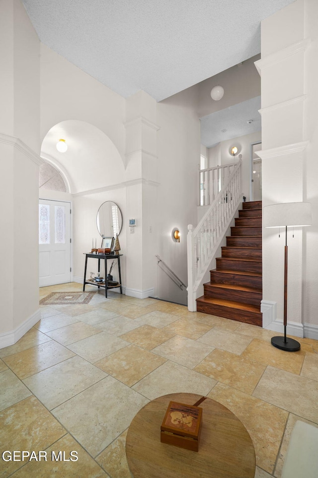 foyer entrance featuring a textured ceiling and a high ceiling