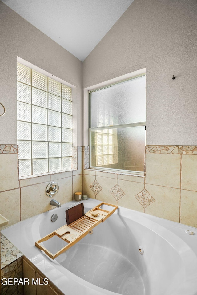 bathroom featuring a bathing tub and vaulted ceiling