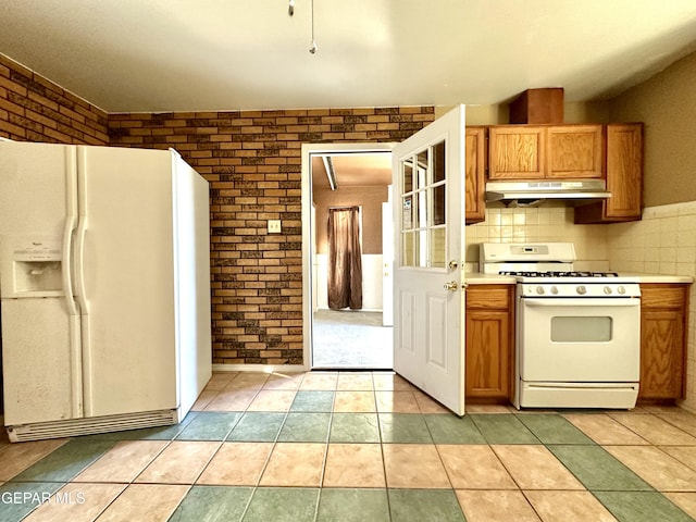 kitchen with white appliances, light tile patterned flooring, decorative backsplash, and brick wall