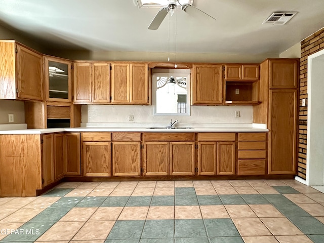 kitchen featuring ceiling fan, sink, and light tile patterned floors