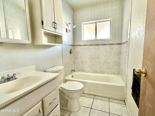 full bathroom featuring tile patterned floors, toilet, tiled shower / bath combo, and vanity