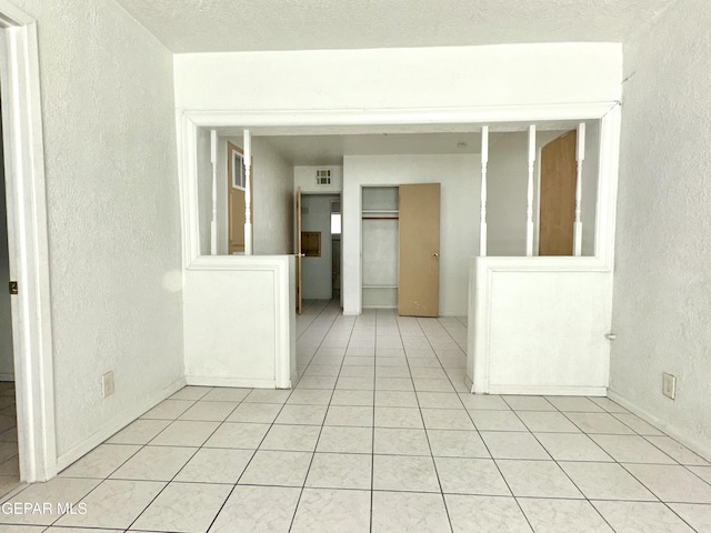 tiled spare room with a textured ceiling