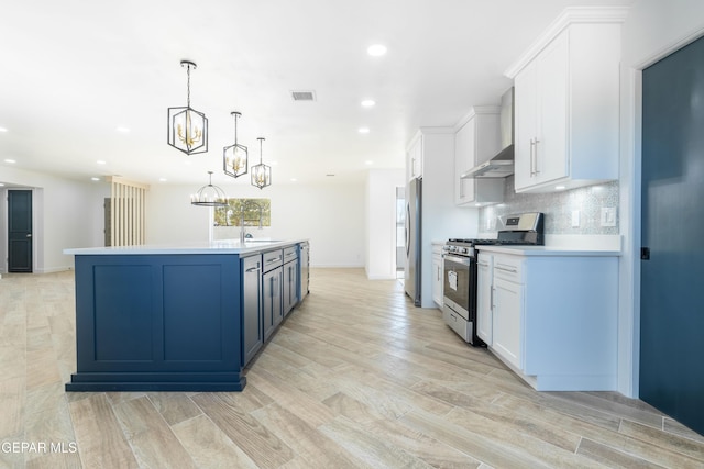 kitchen with white cabinetry, decorative light fixtures, stainless steel appliances, and a center island with sink