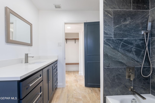 bathroom featuring vanity and tiled shower / bath combo