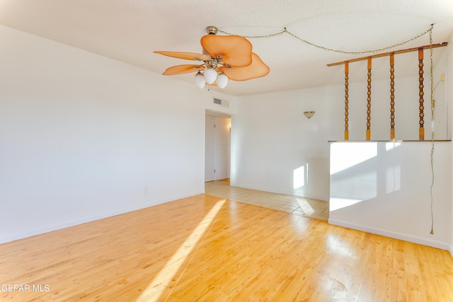 unfurnished room with hardwood / wood-style floors, a textured ceiling, and ceiling fan