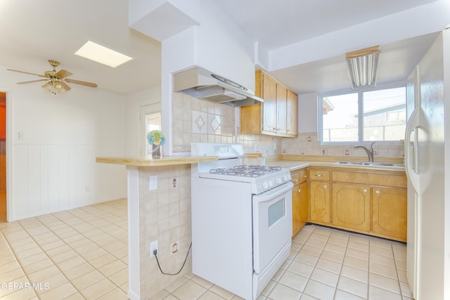 kitchen featuring sink, light tile patterned floors, white appliances, and decorative backsplash