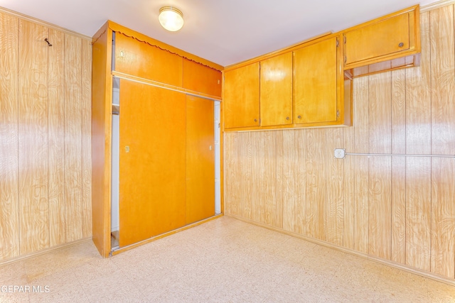 unfurnished room featuring wood walls