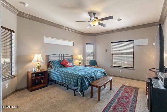 bedroom with ornamental molding, light carpet, ceiling fan, and a textured ceiling