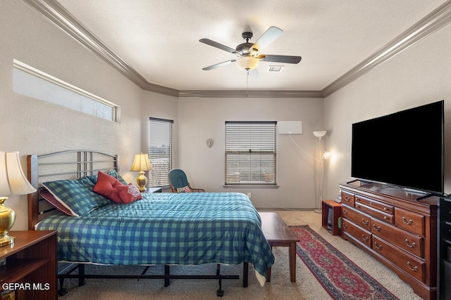 carpeted bedroom with ornamental molding and ceiling fan