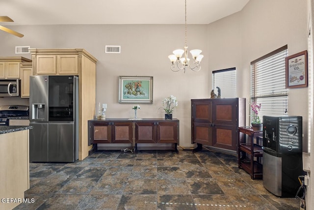 kitchen with hanging light fixtures, ceiling fan with notable chandelier, and stainless steel appliances