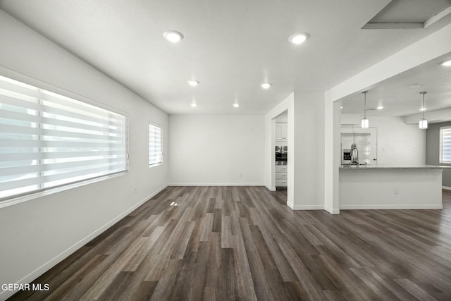 unfurnished living room with sink and dark hardwood / wood-style flooring