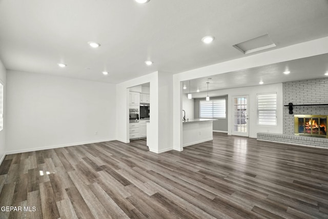 unfurnished living room with a fireplace and dark hardwood / wood-style flooring