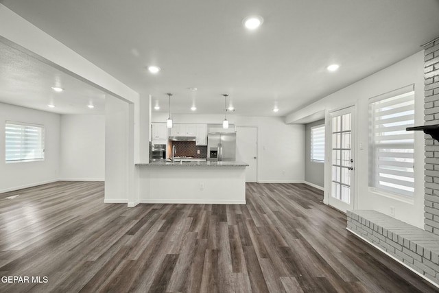 unfurnished living room with plenty of natural light and dark hardwood / wood-style floors