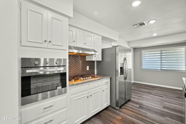 kitchen featuring white cabinetry, appliances with stainless steel finishes, dark hardwood / wood-style flooring, and tasteful backsplash