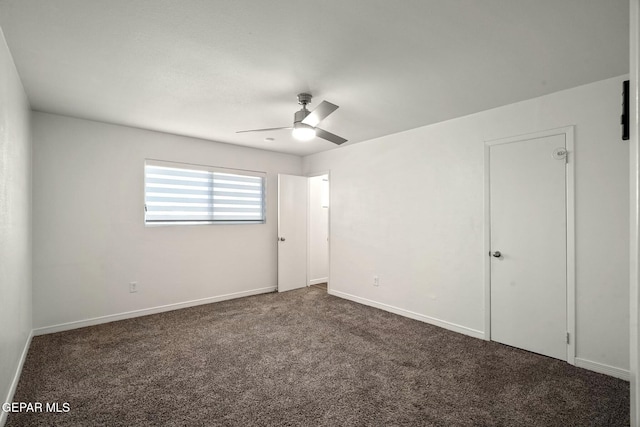 unfurnished room with ceiling fan and dark carpet