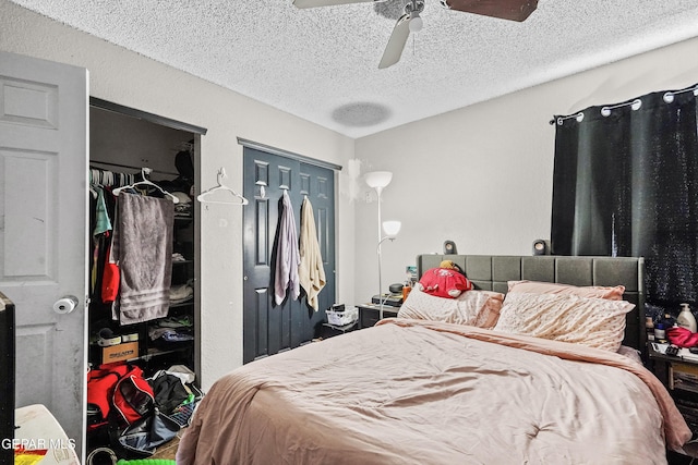 bedroom featuring ceiling fan, a textured ceiling, and two closets