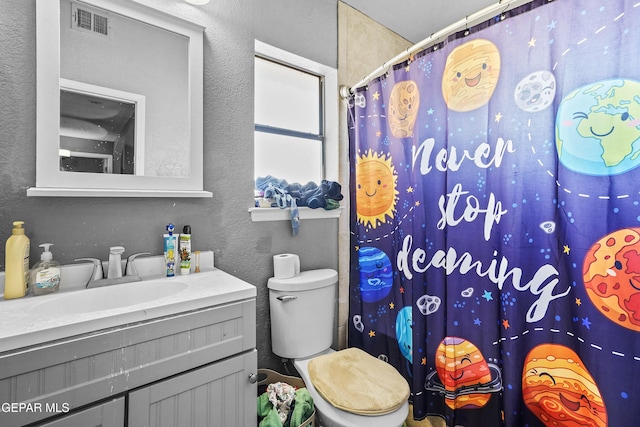 bathroom featuring walk in shower, vanity, and toilet