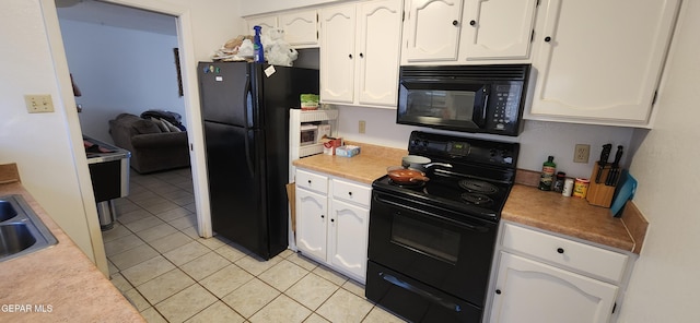 kitchen featuring white cabinetry, sink, light tile patterned floors, and black appliances