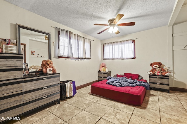 bedroom featuring ceiling fan, a textured ceiling, and light tile patterned flooring