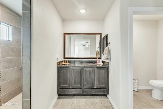 bathroom featuring vanity, tile patterned floors, toilet, and a tile shower