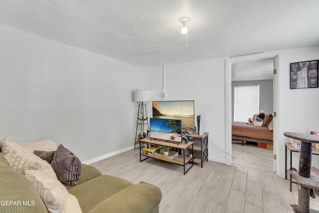 living room featuring light hardwood / wood-style flooring and a textured ceiling