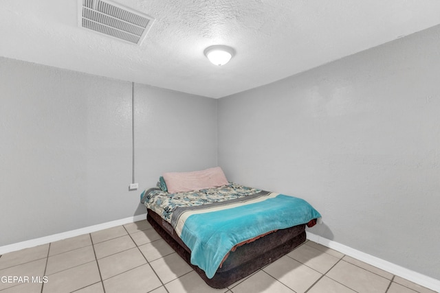 tiled bedroom with a textured ceiling