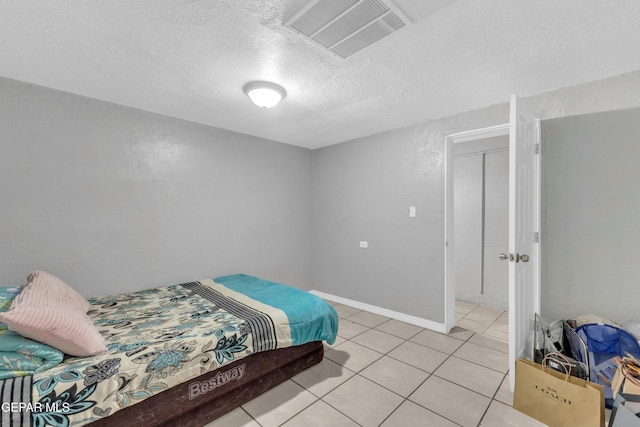 tiled bedroom with a textured ceiling