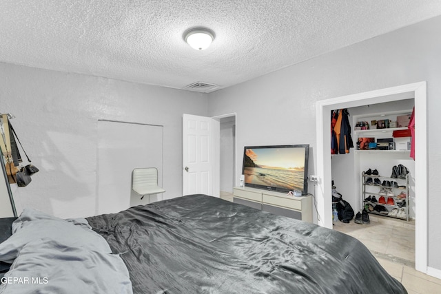 bedroom featuring light tile patterned floors and a textured ceiling