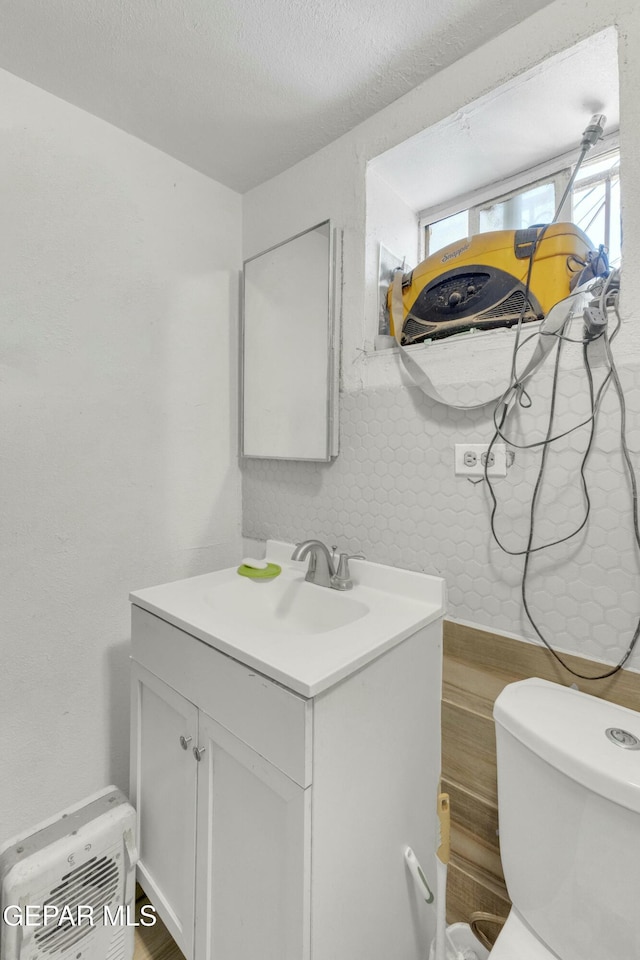 bathroom with vanity, a textured ceiling, and toilet