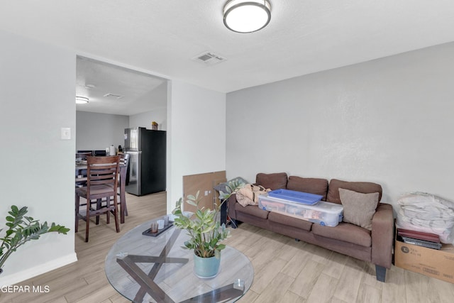 living room with light hardwood / wood-style flooring and a textured ceiling