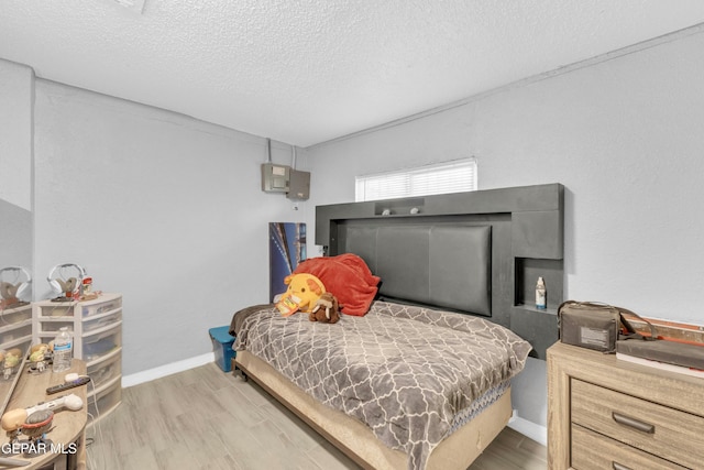 bedroom featuring wood-type flooring and a textured ceiling