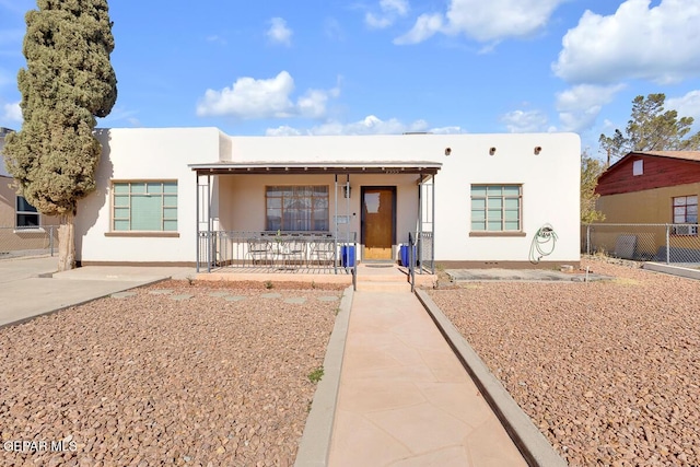 pueblo revival-style home with covered porch