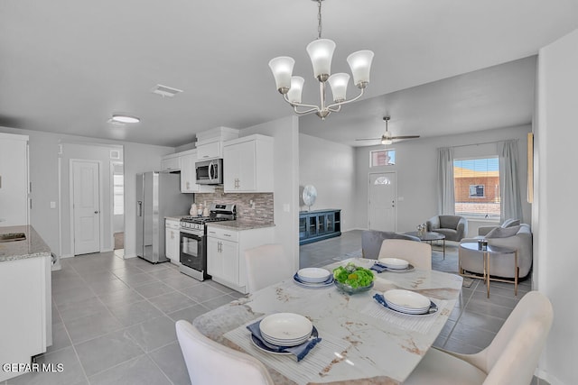 dining area featuring ceiling fan with notable chandelier and light tile patterned floors