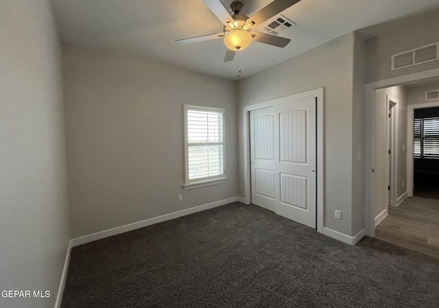 unfurnished bedroom featuring dark carpet, a closet, and ceiling fan