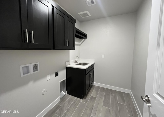 clothes washing area with cabinets, gas dryer hookup, sink, and washer hookup