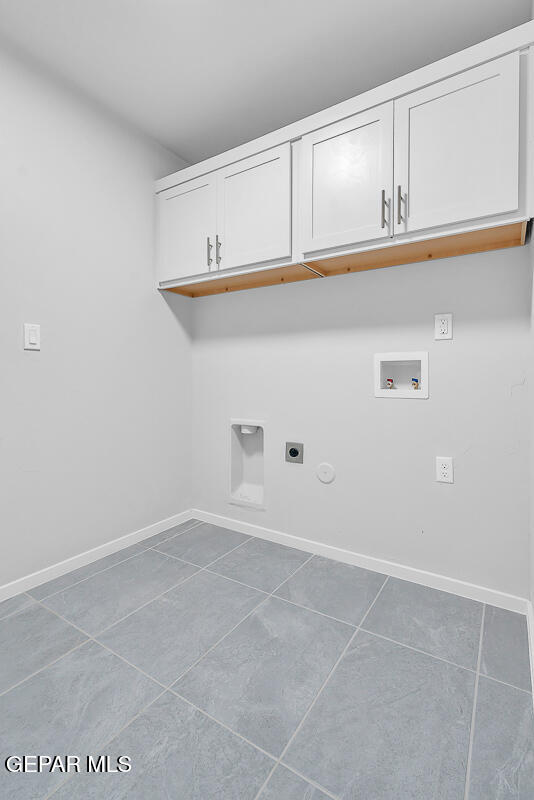 clothes washing area with electric dryer hookup, tile patterned flooring, cabinets, washer hookup, and hookup for a gas dryer