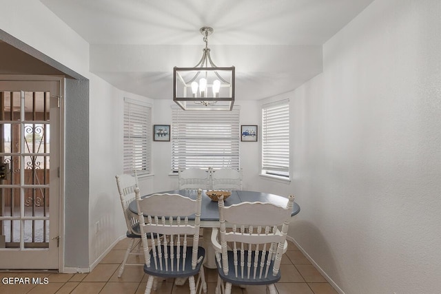 tiled dining space with an inviting chandelier