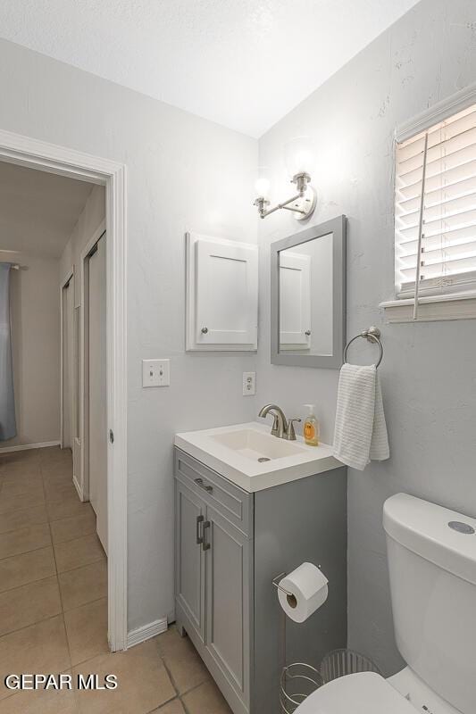 bathroom featuring vanity, tile patterned floors, and toilet