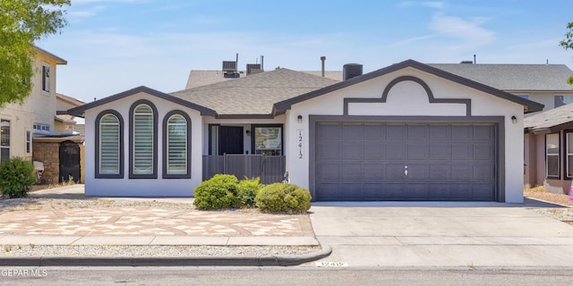 ranch-style house with a garage and central air condition unit