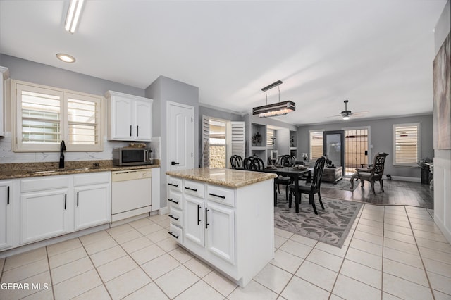 kitchen with sink, white cabinetry, decorative light fixtures, white dishwasher, and a kitchen island