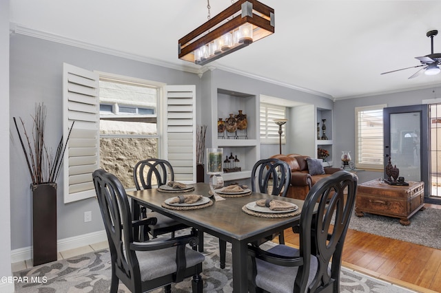 dining area featuring ceiling fan, ornamental molding, and light wood-type flooring