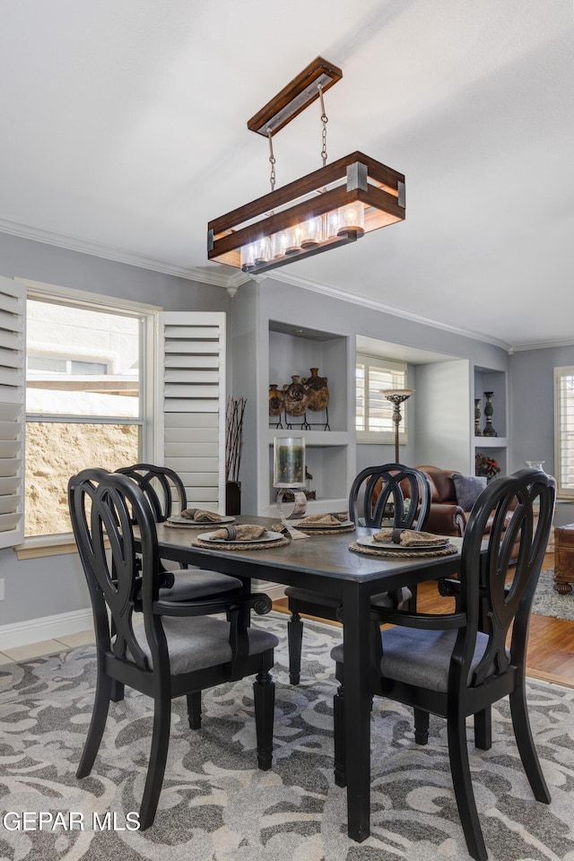 dining room featuring hardwood / wood-style floors, built in features, plenty of natural light, and ornamental molding