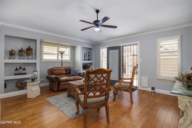 living room featuring ceiling fan, ornamental molding, wood-type flooring, and built in features